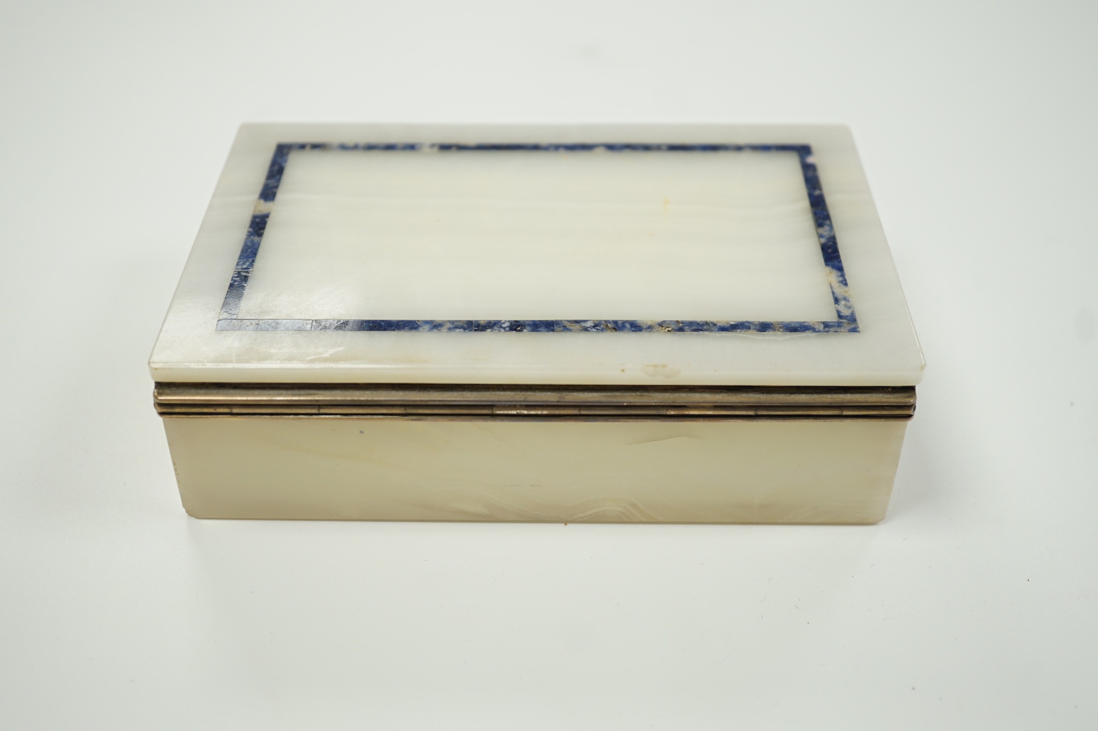 A George V silver mounted, lapis lazuli banded white onyx rectangular cigarette box, George Betjemann & Sons, London, 1919, 15.3cm.